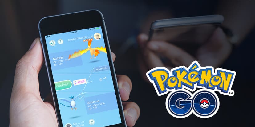 手のひらに持ったスマートフォンでポケモンGOのトレード画面(ファイヤーとフリーザーの交換)を操作している様子。右側に「Pokémon GO」のロゴが並んでいる